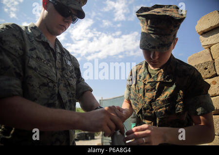 Sgt. Alex Micciche, an explosive ordnance disposal technician, and Cpl. Jessica Lucy, a combat engineer, prepare a counter-improvised explosive device tool during a range near Naval Air Station Sigonella, Italy, May 24, 2016.  EOD Marines with Special Purpose Marine Air-Ground Task Force Crisis Response-Africa used precision energetic tools to safely render an IED useless.  (U.S. Marine Corps photo by Cpl. Alexander Mitchell/released) Stock Photo