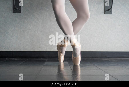 Ballerina dancer in the ballet studio en pointe in releve fourth position Stock Photo