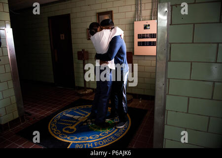 Airman 1st Class Alexandra Ayub, a missile chef, hugs her husband, Airman 1st Class Ozzie Galvan, before leaving her home at Francis E. Warren Air Force Base, Wyoming, for a four-day deployment to a missile alert facility. Ayub provides three meals a day for the Airmen stationed at the MAFs. (U.S. Air Force photo/Staff Sgt. Andrew Lee) Stock Photo