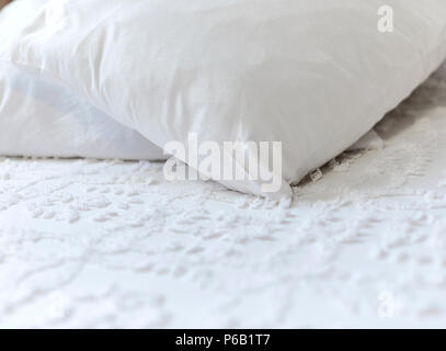 White pillows laying on a white bedspread with shallow depth of field Stock Photo
