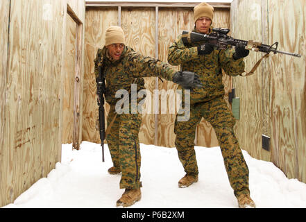 Lance Cpl. Samuel L. Posey (left), a rifleman with 3rd Platoon, Company I, 3rd Battalion, 25th Marine Regiment, 4th Marine Division, Marine Forces Reserve and Cpl. Robert D. Ray (right), a team leader with 3rd Platoon, simulate tossing a fragmentation grenade during a room clearing drill during exercise Arctic Eagle at Camp Grayling, Mich., April 7, 2016. When Posey is not wearing the uniform, he serves his community through Dance Over Anything, a dance group that performs in schools as a way to reach out to less fortunate children. (U.S. Marine Corps photo by Sgt. Ian Leones/Released) Stock Photo