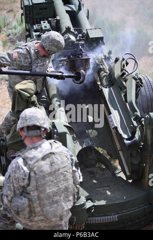 Oregon Army National Guard Soldiers with Charlie Battery, 2nd Battalion, 218th Field Artillery Regiment, 41st Infantry Brigade Combat Team, clean off the bore during a familiarization fire with their M777A Howitzers, May 23, at the Yakima Training Center near Yakima, Washington. The unit conducted the firing as part of their two-week annual training. (Photo by Capt. Leslie Reed, 41st Infantry Brigade Combat Team Public Affairs) Stock Photo