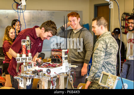 Cornell University Mars Rover Team students collaborate with faculty advisors while working on a rover for the University Mars Rover Challenge in Phillips Hall, Ithaca, NY. The work involves design review, system integration, STEM education, robotics, testing procedures, team coordination, technical planning, model analysis, prototyping, and preparation for competitive evaluation in aerospace and mechanical engineering projects. Stock Photo