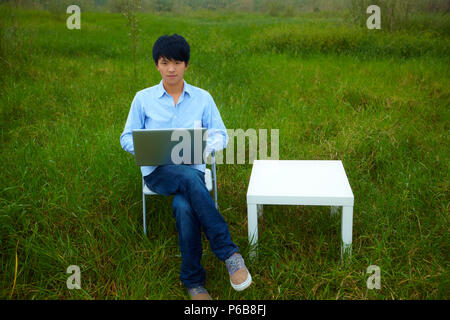 Young asian man using computer in home office Stock Photo