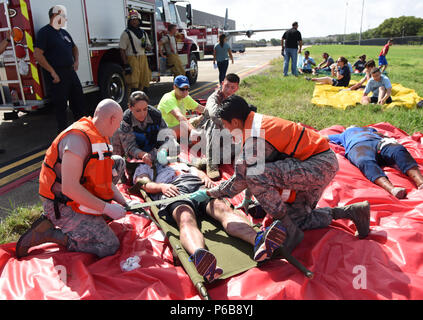 Members of the 81st Medical Group provide triage to “victims” during a major accident response exercise on the flight line at Keesler Air Force Base, Mississippi, June 21, 2018. The exercise scenario simulated a C-130J Super Hercules in-flight emergency causing a plane crash which resulted in a mass casualty response event. This exercise tested the base’s ability to respond in a crisis situation. (U.S. Air Force photo by Kemberly Groue) Stock Photo