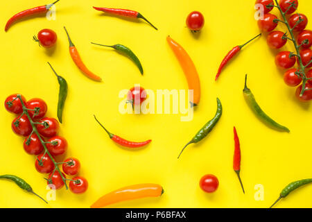 Assorted chili pepper tomato cherry On yellow bright background. Stock Photo