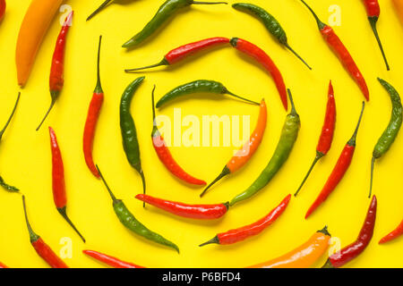Assorted chili pepper tomato cherry On yellow bright background. Stock Photo
