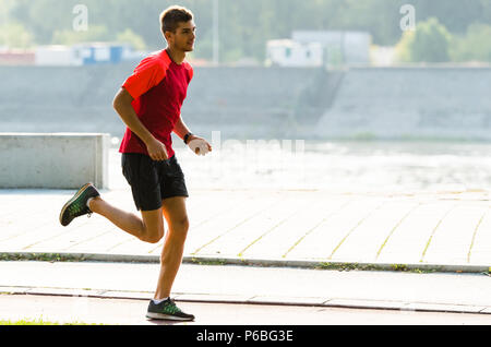 Young sporty man jogging outdoor Stock Photo