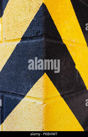 Yellow and black warning stripes on the corner of the building Stock Photo