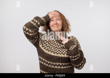 Portrait of sick ill european female dressed in big wool brown sweater. Woman suffering from physical discomfort because of fever. Caucasian girl has  Stock Photo
