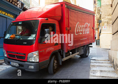 Coca Cola truck / lorry in the narrow streets and roads of the historic old city centre of Valletta, Malta, while it makes its deliveries of cola and makes collections of empty bottles. Stock Photo