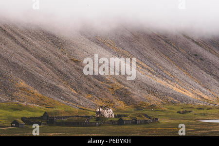 old viking village in iceland with foggy hill. old wooden buildings covered grass Stock Photo