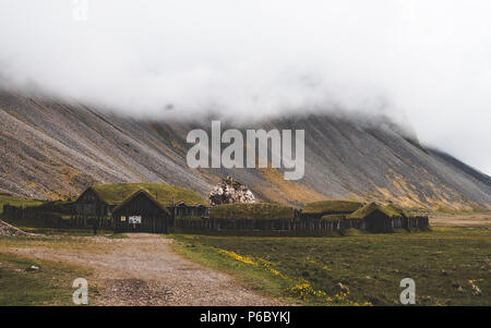 old viking village in iceland with foggy hill. old wooden buildings covered grass Stock Photo