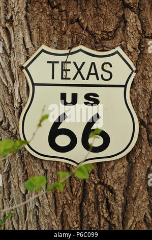 A replica Route 66 highway sign is displayed on a tree in Texas. The legendary US 66 crosses the Texas Panhandle on its journey from Chicago to L.A. Stock Photo