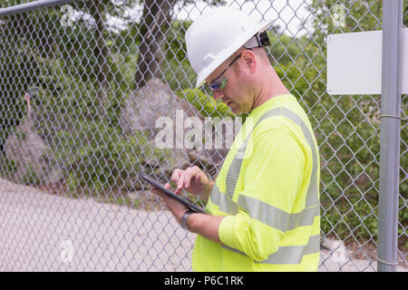 Engineer at an electric power plant checking his tablet Stock Photo