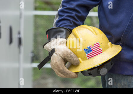 Engineer carrying hard hat with rubber protective gloves Stock Photo