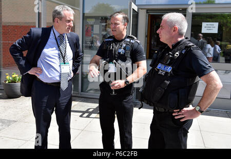 Damian Hinds (left), Conservative MP for East Hampshire and Secretary of State for Education, in conversation with police officers during a visit to a