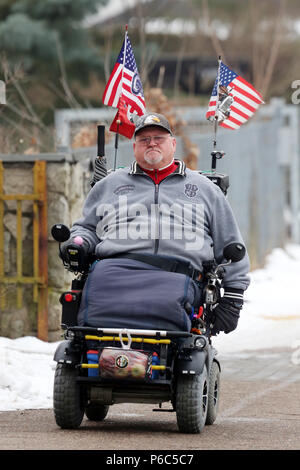 Neuenhagen, man drives his US-flagged electric wheelchair on the day of the swearing-in of US President Donald Trump Stock Photo