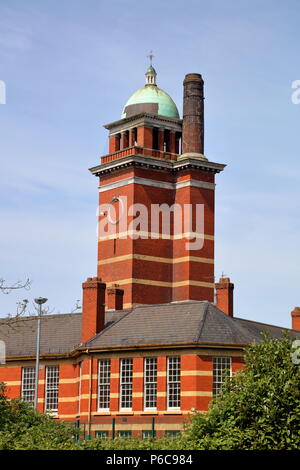 The tall tower of the old Velindre hospital towers above the other building surrounding it, showing off ornate brickwork and masonry detail. Stock Photo