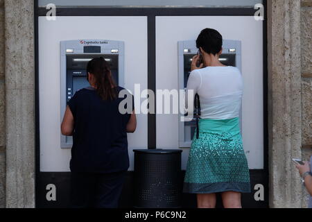 Unidentified girl withdrawing money from an ATM machine in city center of Zagreb Stock Photo