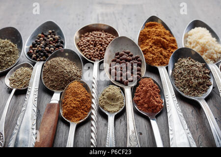 Different spices in  spoons on a wooden background. Stock Photo