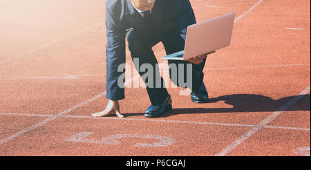 A businessman on a track ready for race in business Stock Photo