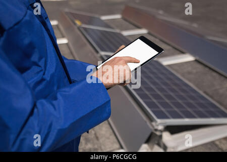 Male worker using digital tablet at solar station Stock Photo
