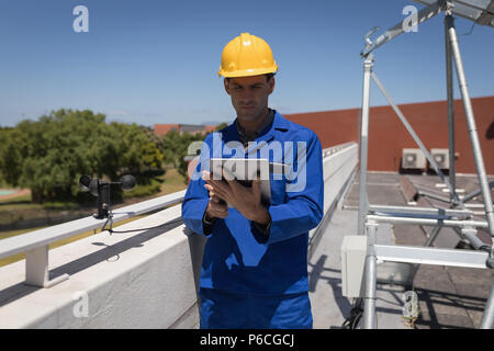 Male worker using digital tablet at solar station Stock Photo