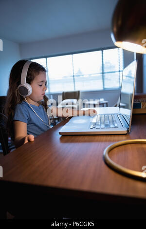 Girl listening to music on laptop Stock Photo