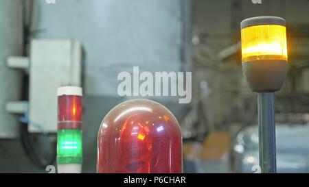 Warning light on a processing machine. Closeup flashing red lamp on machine in toilet paper production plant large workshop. Red siren on metal cabine Stock Photo