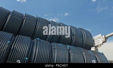 Warehouse of finished plastic pipes industrial outdoors storage site. Manufacture of plastic water pipes factory. Process of making plastic tubes on t Stock Photo