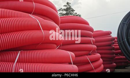 Warehouse of finished plastic pipes industrial outdoors storage site. Manufacture of plastic water pipes factory. Process of making plastic tubes on t Stock Photo