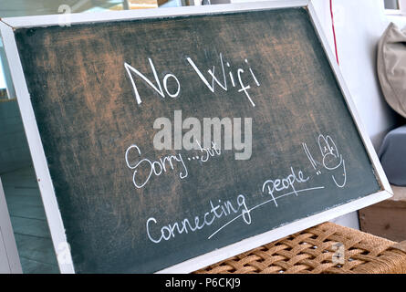 No Wi Fi sign. Sorry, but connecting people - chalk text written on blackboard at restaurant. Talk to each other concept Stock Photo