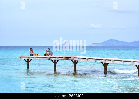 Formentera Island, Spain - May 4, 2018: People taking a picture in the wooden boardwalk, picturesque view to the turquoise water at the Formentera Isl Stock Photo