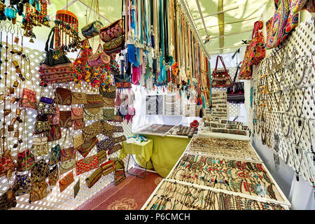 Ibiza Island, Spain - May 2, 2018: Stall full of a handmade fashion accessories, silver jewellery with precious gems and bohemian style of bags in the Stock Photo