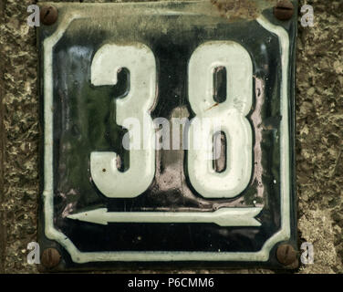 Weathered grunge square metal enameled plate of number of street address with number 38 closeup Stock Photo