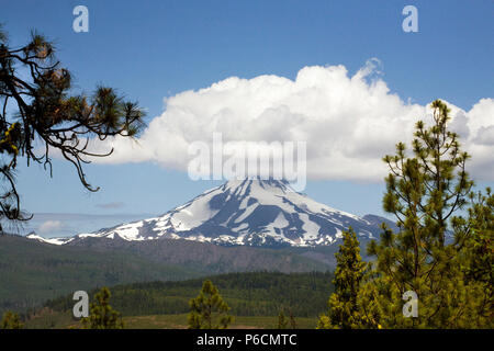 A large cumulus cloud sits atop Mount Jefferson, Oregon's second highest peak, like a hat. Jefferson is a dormant volcano in the Cascade Range. Stock Photo