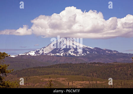 A large cumulus cloud sits atop Mount Jefferson, Oregon's second highest peak, like a hat. Jefferson is a dormant volcano in the Cascade Range. Stock Photo