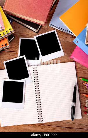 College student desk with blank photo album and polaroid style instant photo print frames Stock Photo