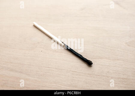 Burned head long wooden safety matchstick on wooden background Stock Photo