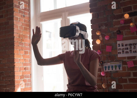Female executive using virtual reality headset Stock Photo