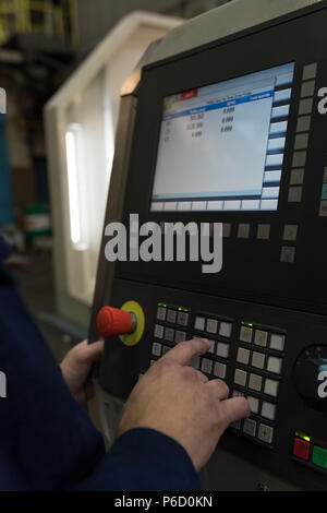 Operating Machine Name Technician operating machinery in modern factory Stock Photo - Alamy