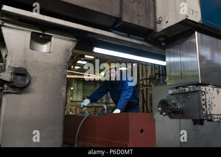 Technician in protective workwear cutting metal Stock Photo