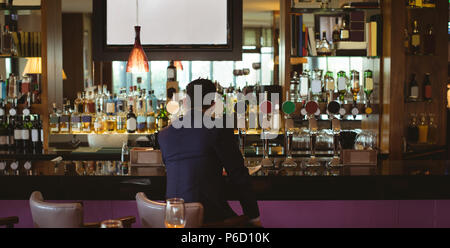 Businessman having a glass of whisky in hotel Stock Photo