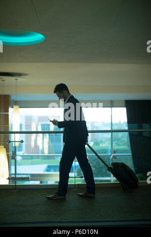 Businessman using mobile phone at corridor Stock Photo