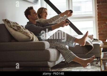 Couple playing video games in living room Stock Photo