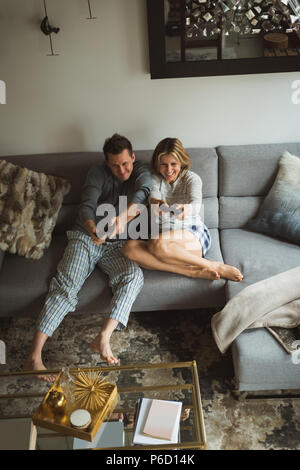 Couple playing video games in living room Stock Photo