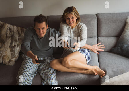 Couple playing video games in living room Stock Photo