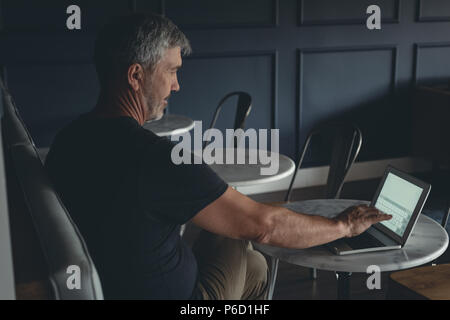 Businessman using laptop in cafeteria Stock Photo