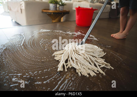 Boy washing the floor with mop at home Stock Photo